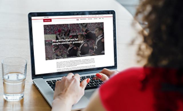 Woman reading Ohio State brand standards on a laptop