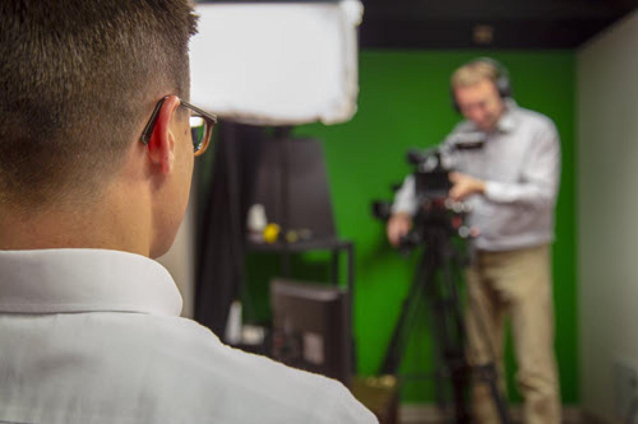 a cameraperson films an interview subject in the campus broadcast studio