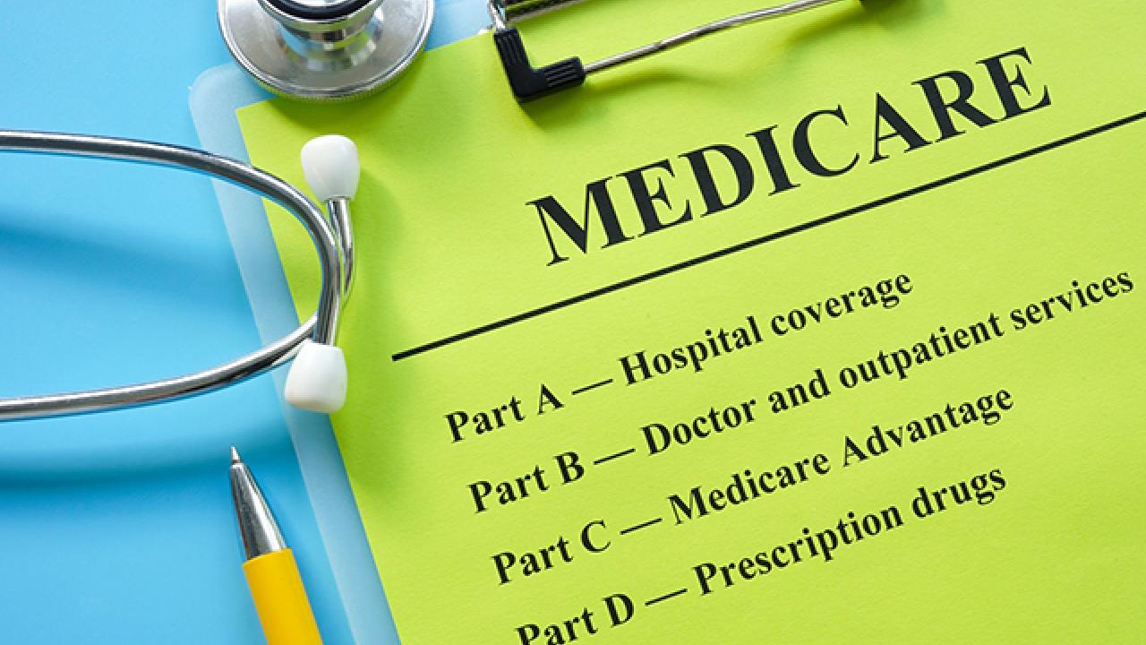 Image of a clipboard with a stethoscope and pen on it. The clipboard has the text &quot;MEDICARE&quot; and the following text below: &quot;Part A Hospital coverage&quot;, &quot;Part B Doctor and outpatient services&quot;, &quot;Part C Medicare Advantage&quot;, and &quot;Part D Prescription drugs&quot;.