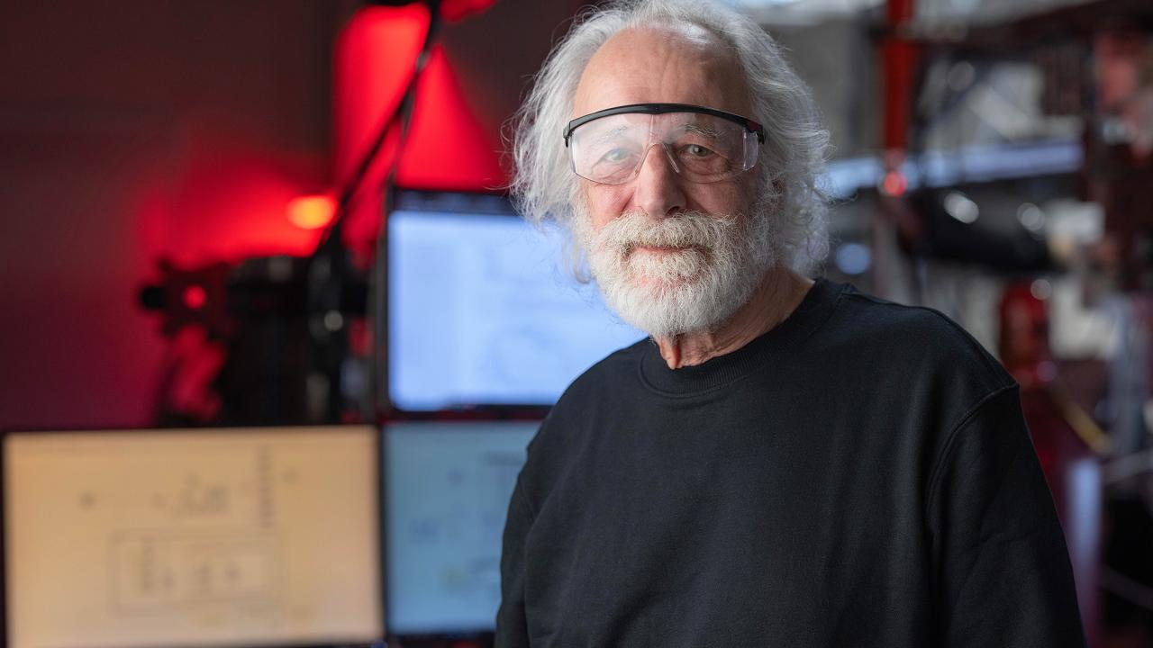Pierre Agostini in red lab wearing safety goggles