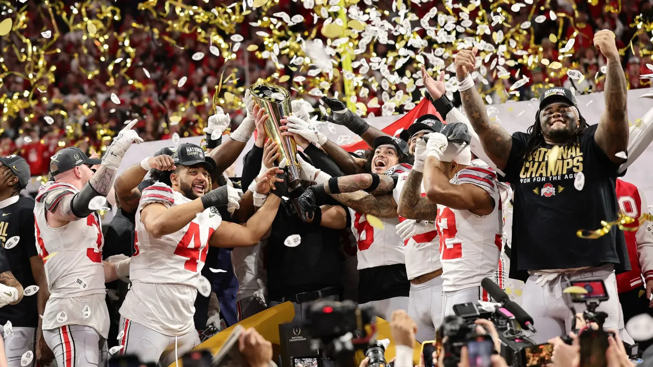 Buckeye football players celebrating with championship trophy