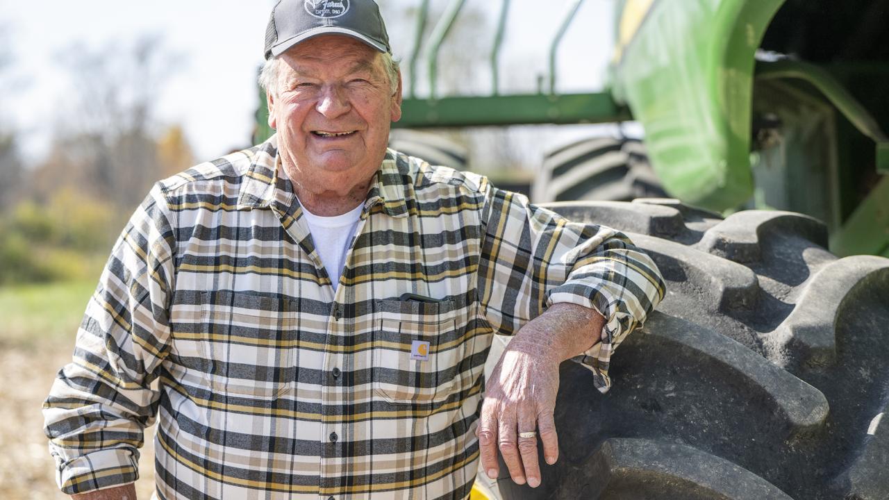 Ohio farmer Len Vonderhaar stands next to his combine